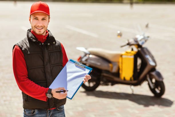 “Motorcycle courier rider with insulated bag comparing delivery insurance plans in the UK”