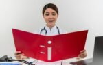 Health Information Management professional updating electronic health records in U.S. hospital